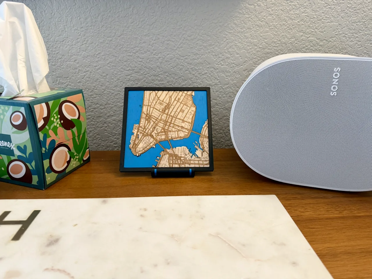 A framed laser-cut map of Lower Manhattan standing on a credenza